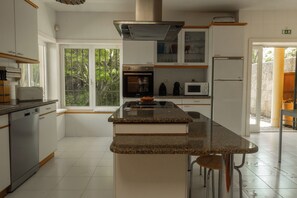 Una cucina moderna con isola centrale, elettrodomestici integrati e vista sul verde.