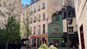 Eine enge Straße mit Häusern, einem Verbotsschild und einem Café.