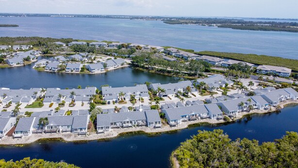 A coastal residential area with houses and a marina. - Perico Bay Club Condo | 30+ Nights, Resort Amenities, Minutes to AMI (Bradenton)