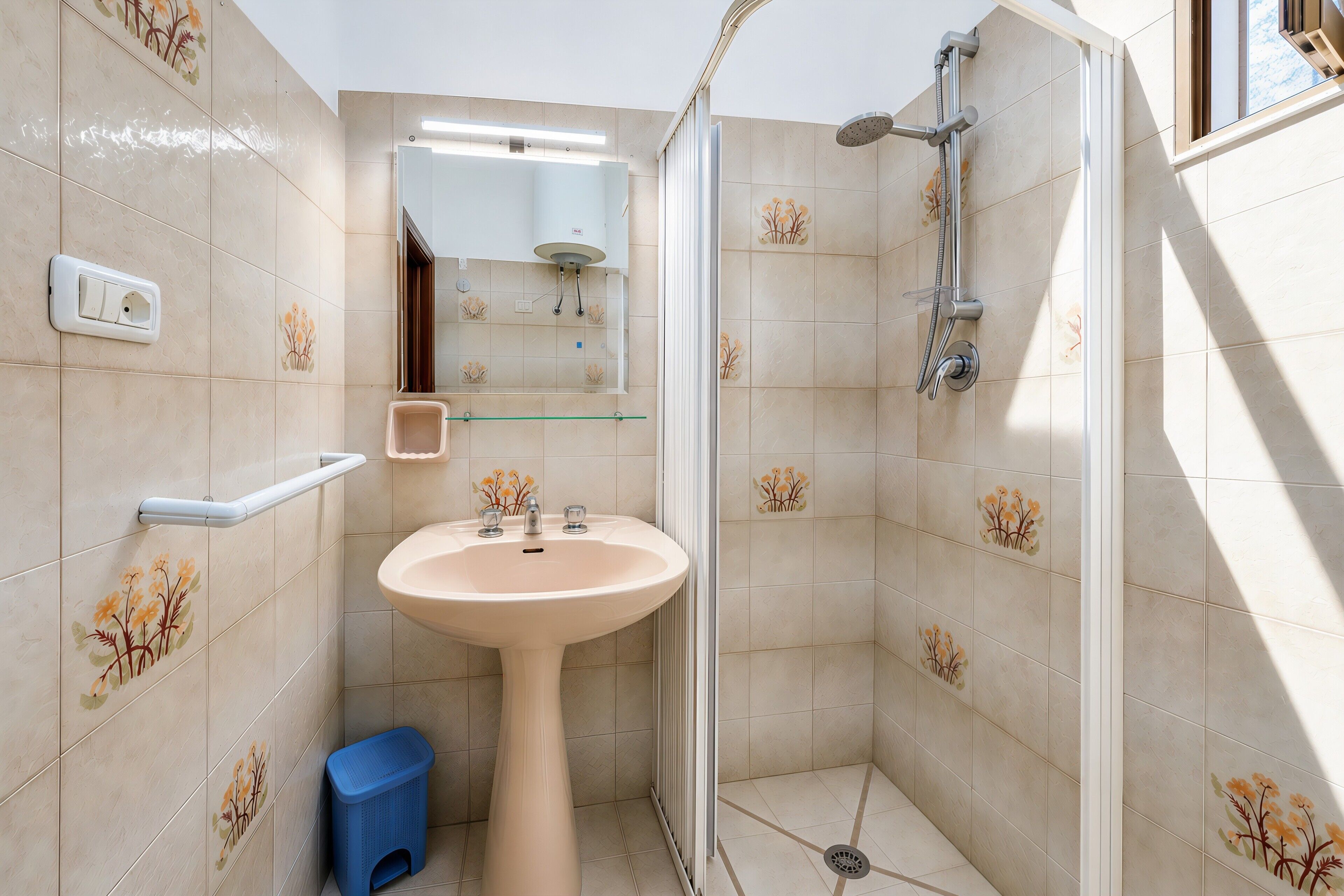 Un bagno con lavandino, specchio, doccia e WC.