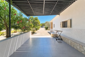 A covered outdoor area with a tiled floor, a table, and a bench. - Casa Vacanze Ervilia apartments on Lungomare E. Mattei, 50 m from the beach (Vieste)