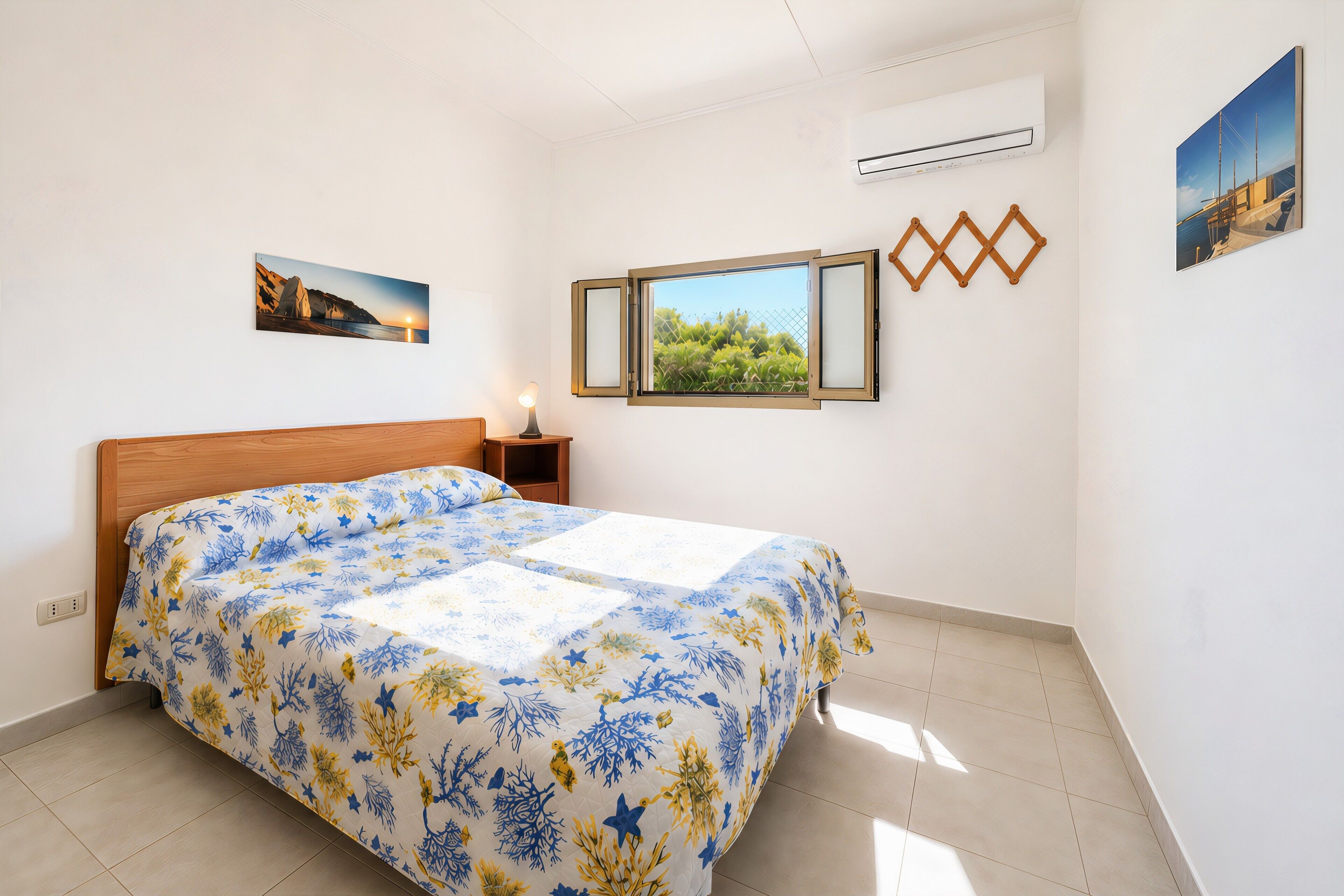A bedroom with a bed, a nightstand, a window, and wall-mounted decorations.