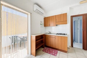 Une cuisine compacte avec des meubles en bois, un évier encastré et un petit coin repas comprenant une table et des chaises.
