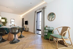 A modern living room with a dining area, a television, and a green side table with cups. - CSE MS MUSEO SELECT (Seville)
