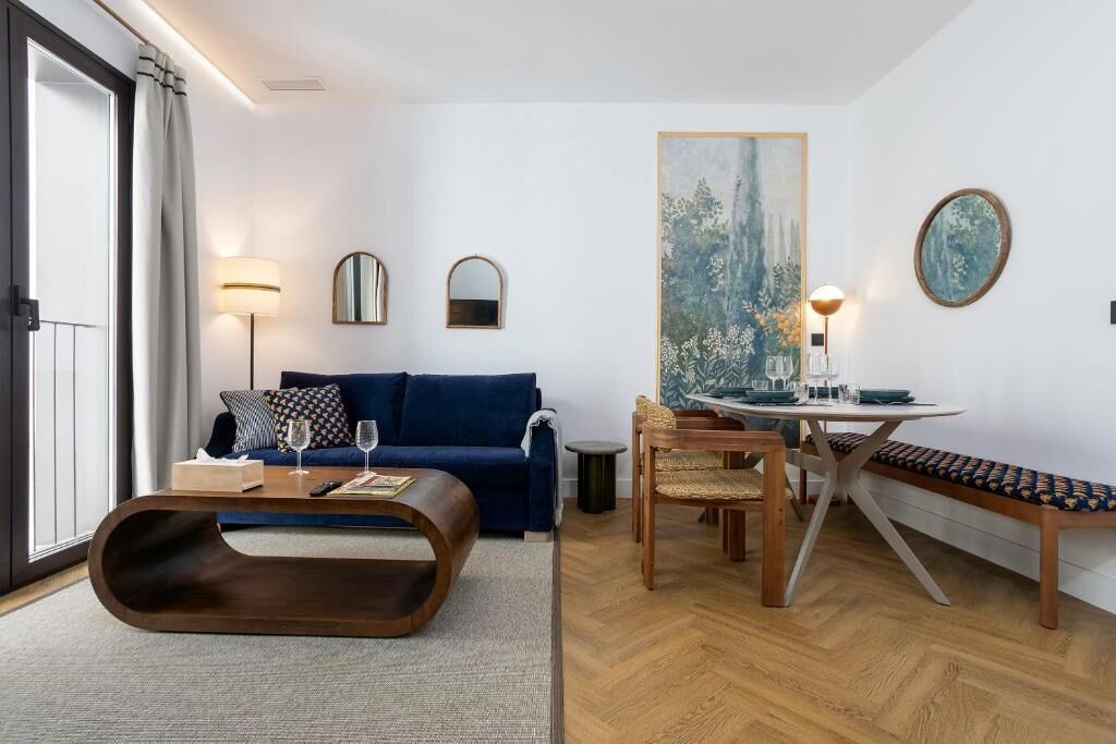 A modern living room with a sofa, coffee table, dining table, and chairs.