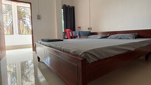 Een slaapkamer met een houten bed, een bureau en een stoel.
