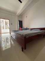 A bedroom with a wooden bed, a desk, and a chair.