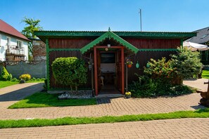 A house with a green roof, a wooden door, and a paved driveway. - Cottage for 4 people, Wapnica (Wapnica)