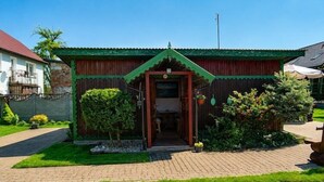 Un bâtiment en bois doté d’un toit végétalisé, d’une entrée pavée et d’un petit jardin.