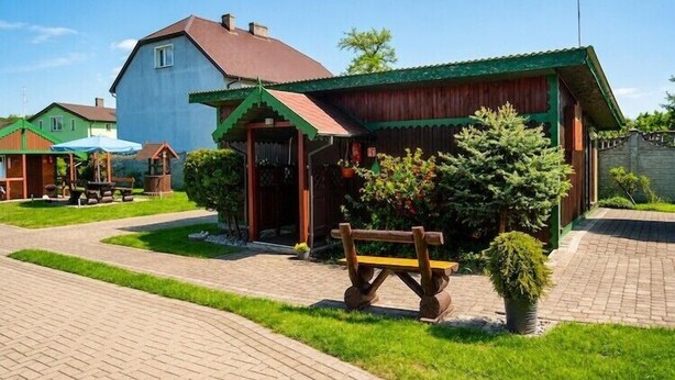 Un quartier résidentiel avec des maisons, un banc en bois et un chemin piétonnier dallé.