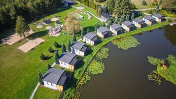 Un quartier résidentiel bordé de maisons, situé le long d’un plan d’eau et entouré de verdure et d’arbres.