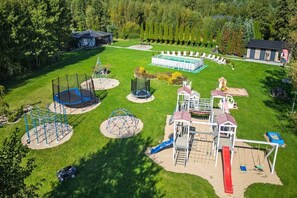 A playground with various play structures, a swimming pool, and a covered seating area. - Holiday cottage no. 2A with private jacuzzi (Darlowo)