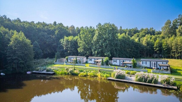 A lakeside property with multiple cabins, a dock, and a forested backdrop. - Holiday cottage no. 2A with private jacuzzi (Darlowo)