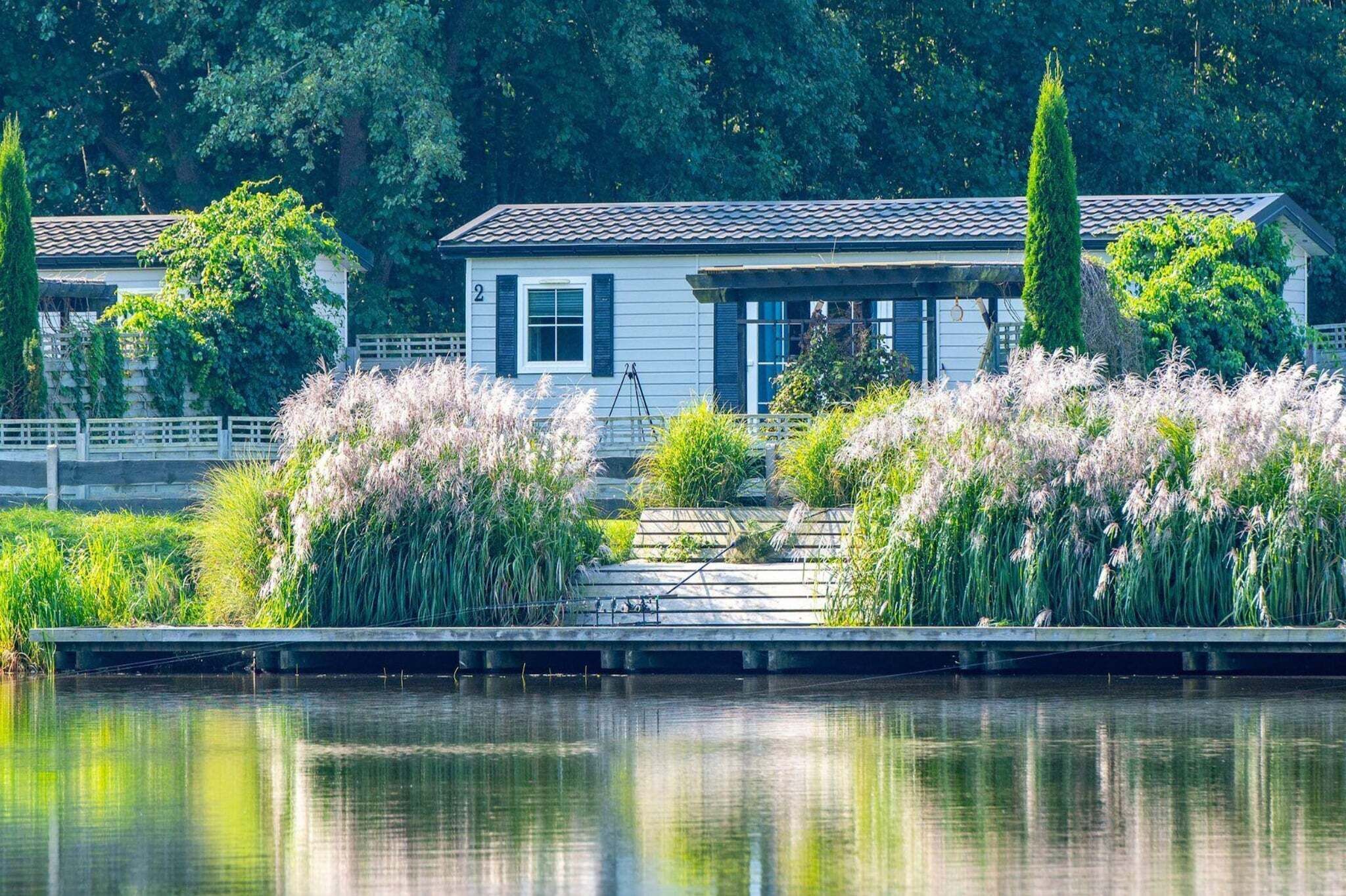 Une propriété au bord du lac, comprenant une maison, un quai et une végétation luxuriante.