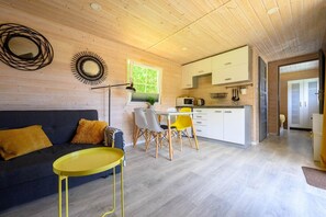 A compact living space with a sofa, dining table, chairs, and a kitchenette. - Holiday cottage no. 4A with private jacuzzi (Darlowo)