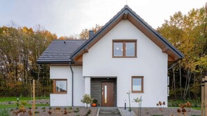 A modern two-story house with a symmetrical facade, a central entrance, and a sloped roof. - Comfortable holiday villa, sauna, jacuzzi (Marcyporeba)