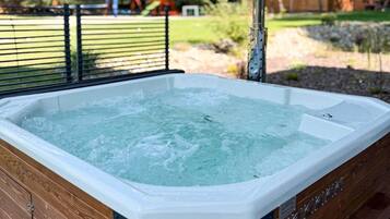 A hot tub with a wooden frame and a metal railing.