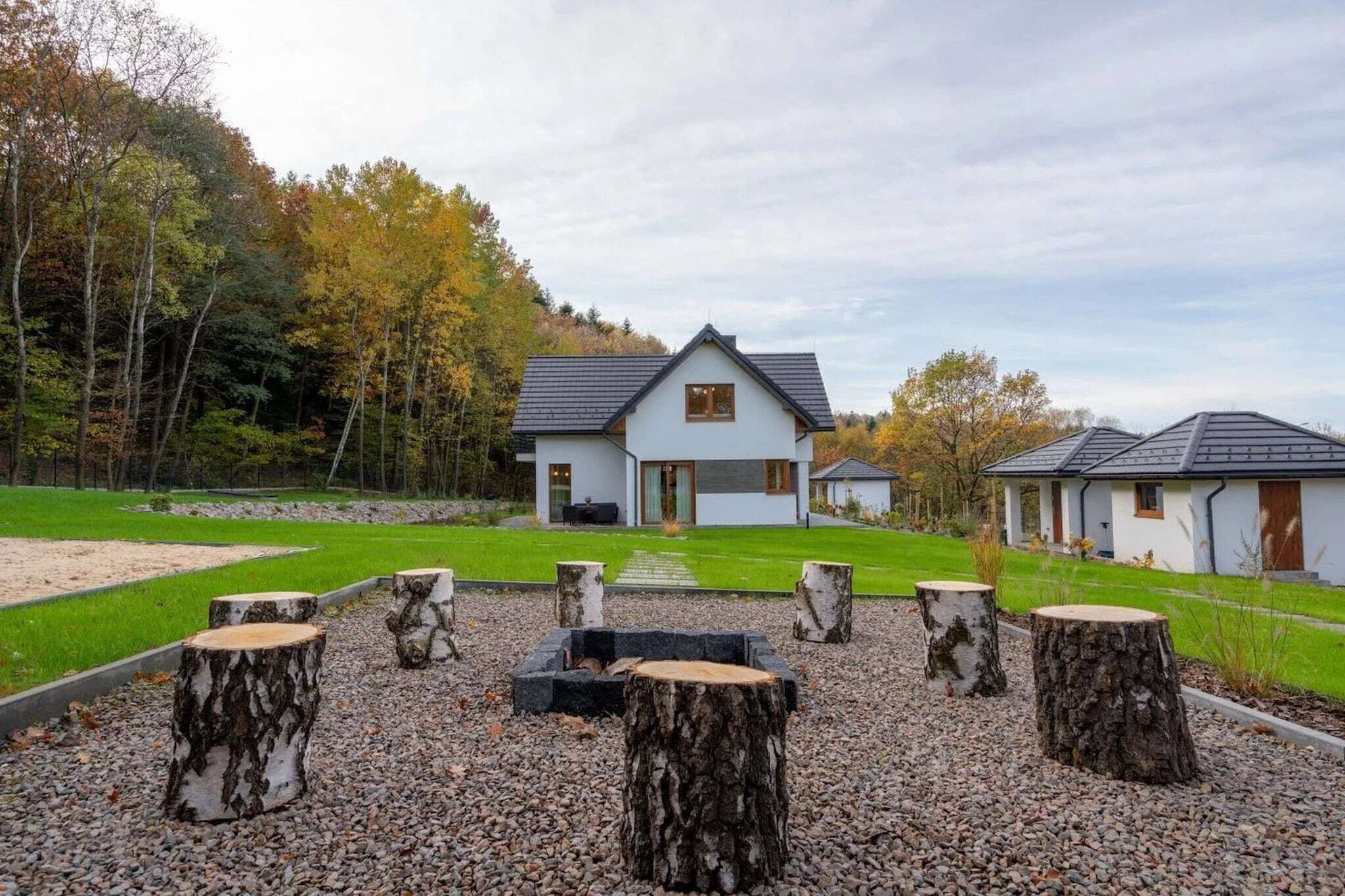 Ein modernes Haus mit Satteldach, umgeben von einem gepflegten Rasen und einem Kiesweg.