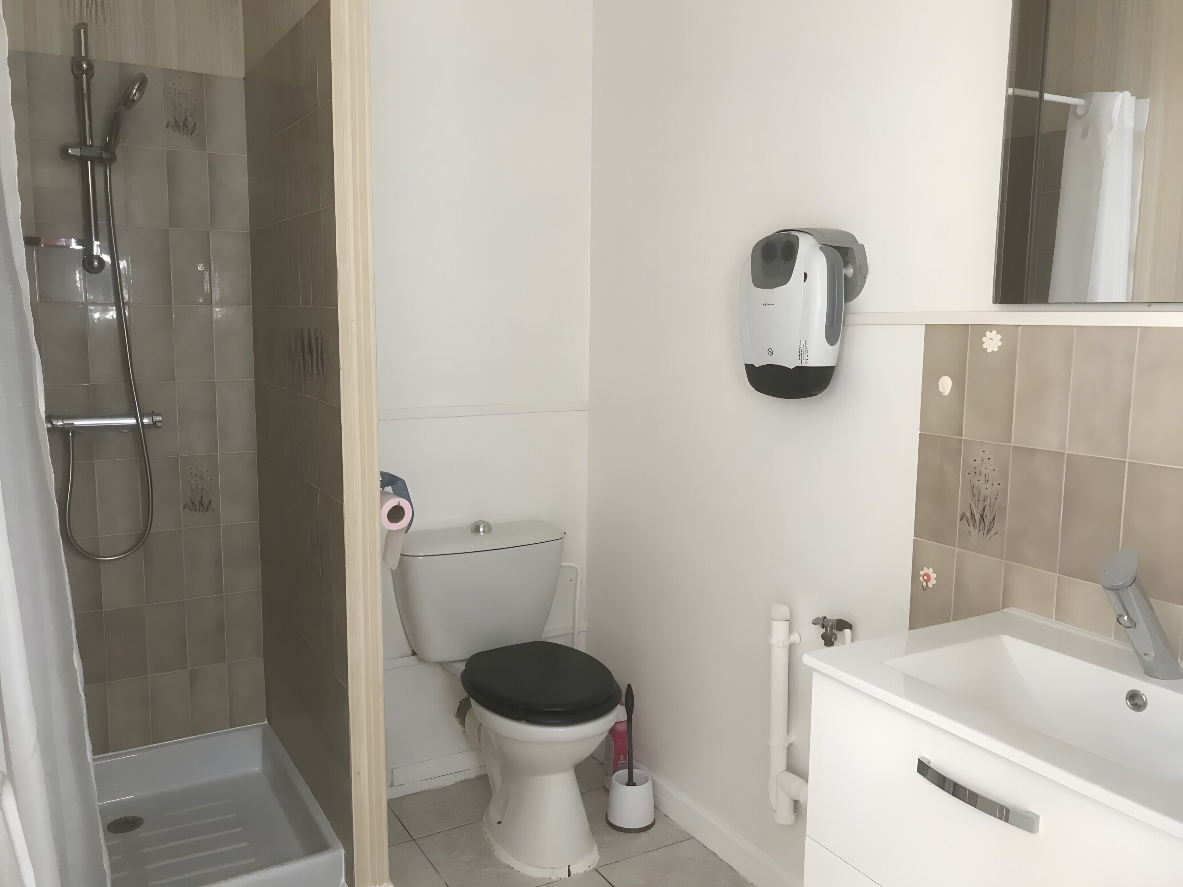 Et badeværelse med brusebad, toilet og vask.