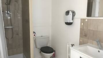 Et badeværelse med brusebad, toilet og vask.