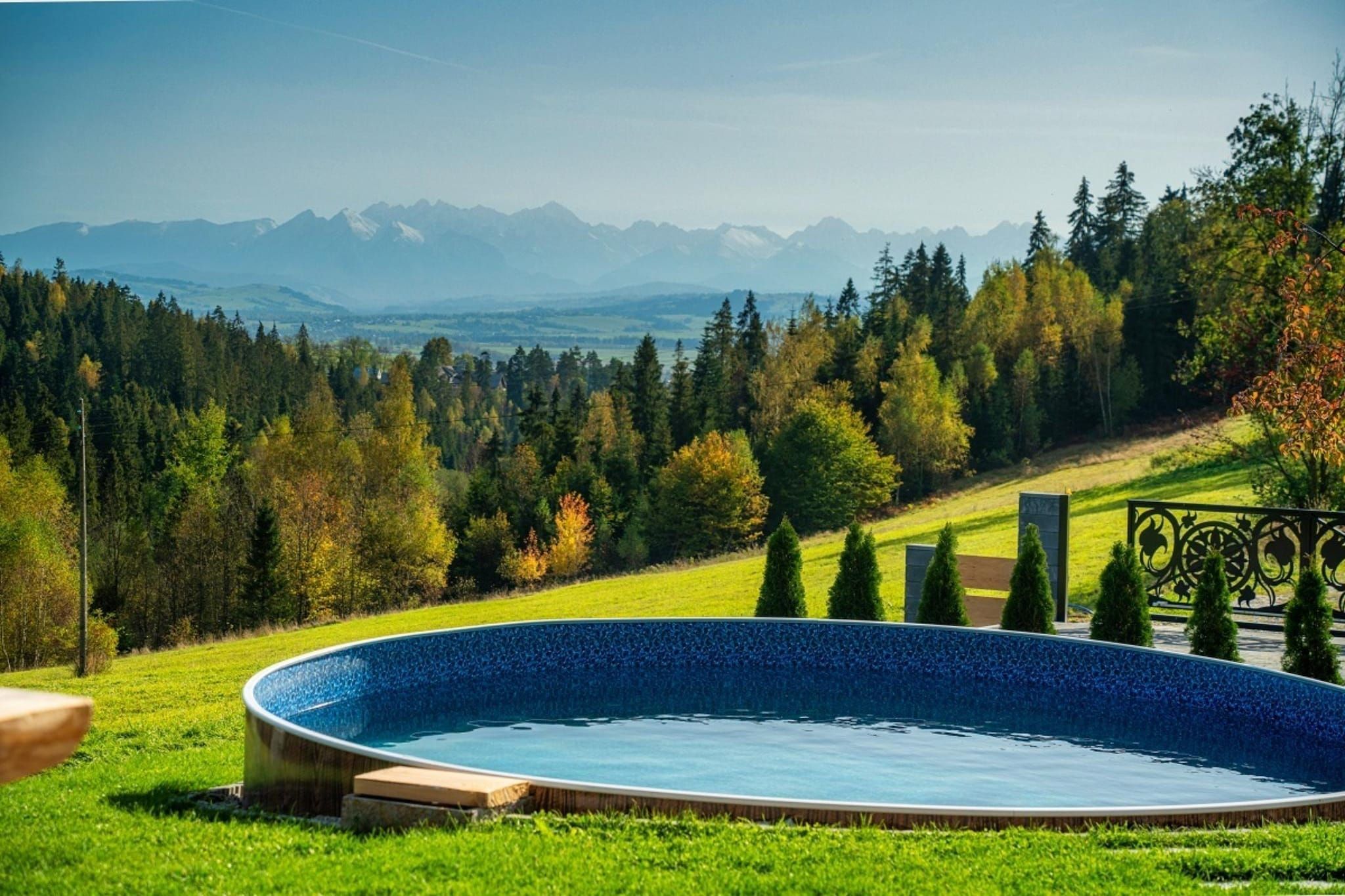 Una piscina con vistas a montañas y árboles.