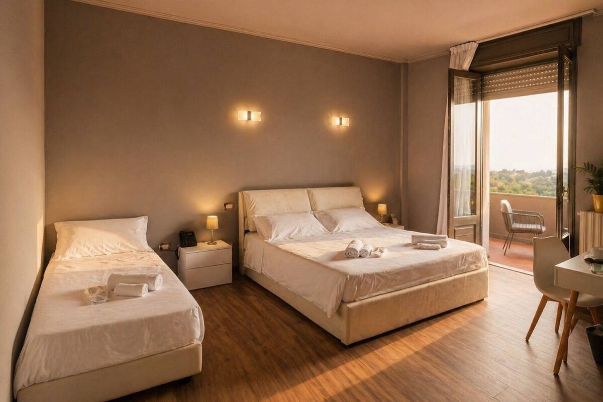 A hotel room with two beds, a balcony with a chair, and a table.