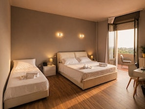Habitación de hotel con dos camas, un balcón con una silla y una mesa.