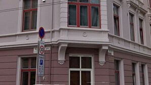 Ein mehrgeschossiges Gebäude mit klassizistischen architektonischen Details, darunter aufwendige Fensterrahmen und Zierleisten.