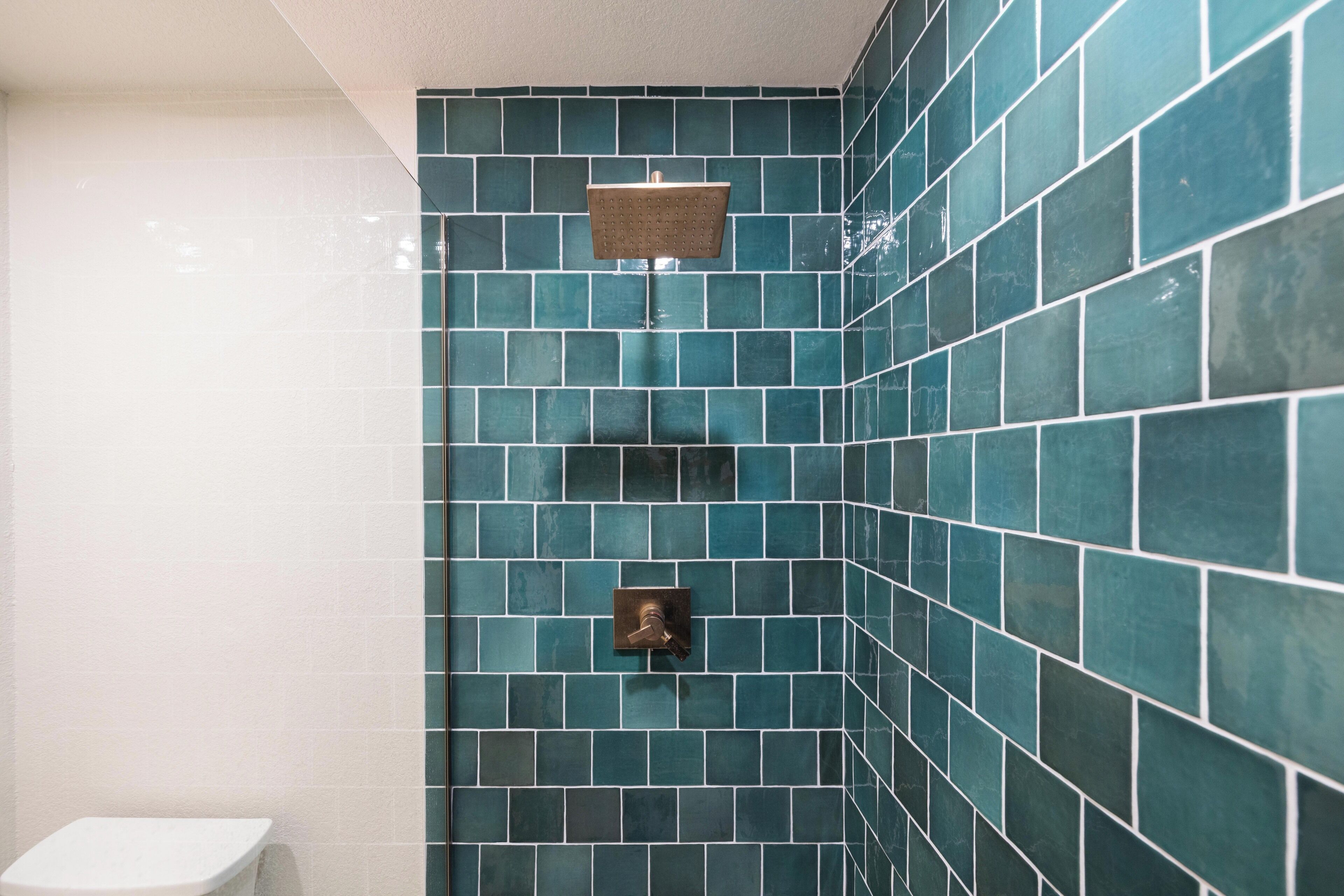A bathroom with a shower, tiled walls, and a toilet.