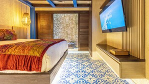 Une chambre à coucher avec un lit, une télévision et une vue sur l’extérieur.
