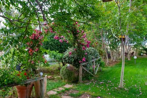 Ein Garten mit blühenden Pflanzen und einer Holzkonstruktion.