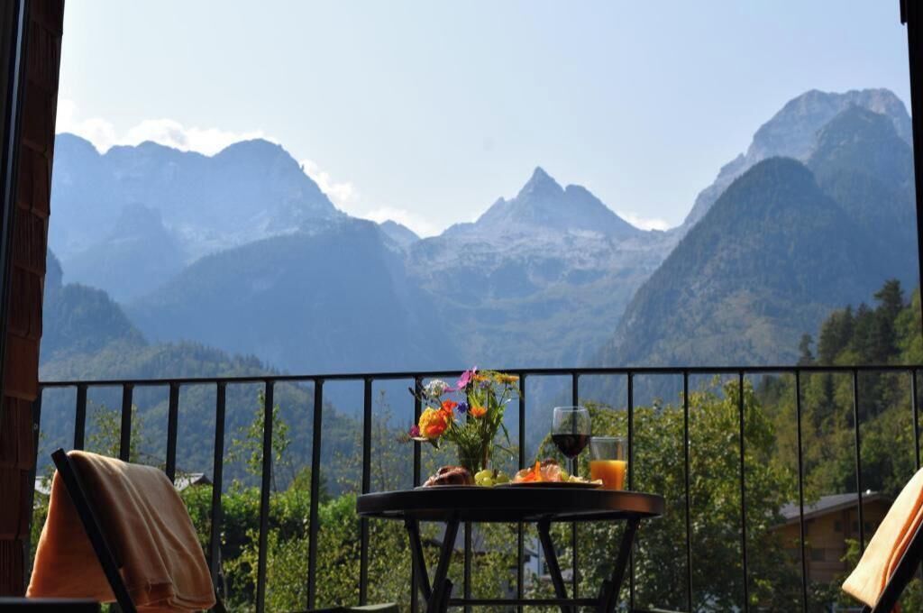 Ein Balkon mit einem Frühstückstisch, mit Blick auf eine Berglandschaft.