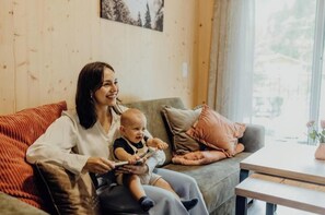Eine Frau und ein Baby sitzen auf einem Sofa mit Blick aus dem Fenster.