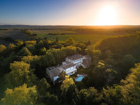 A large house with a swimming pool surrounded by trees.. Mahawellness