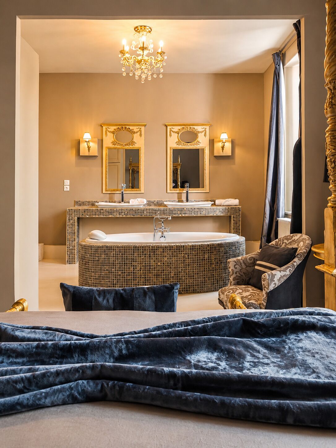 Une salle de bain moderne dotée d’une grande baignoire, de deux vasques et d’un lustre.