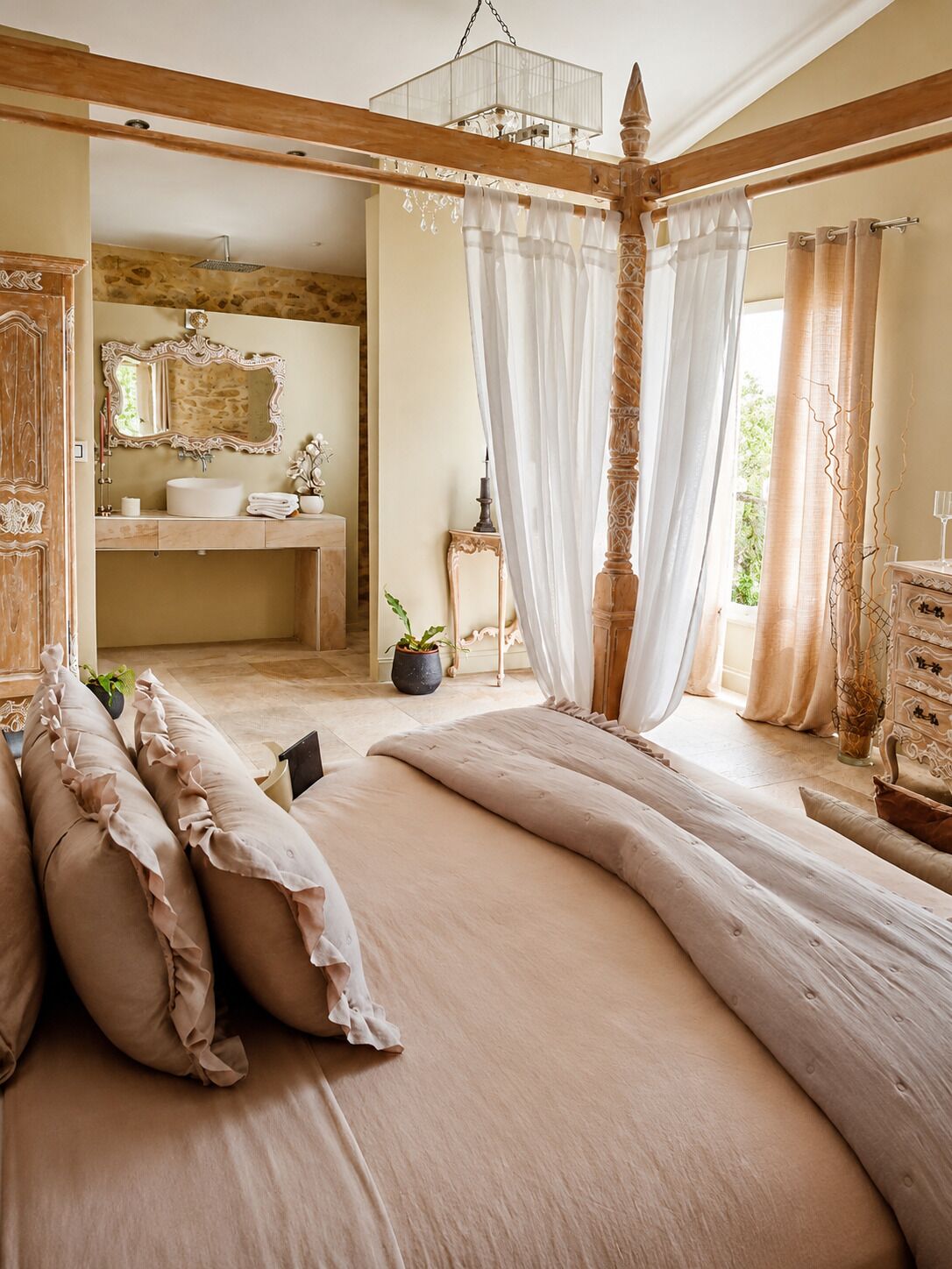 A bedroom with a large bed, a wooden headboard, a bedside table, and a nightstand.