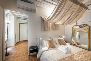 A bedroom with a bed, bedside table, and a large mirror. - Brera luxury apartment (Milano)