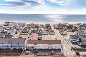 Eine Küstenstadt mit Wohnhäusern, einem Strand und einer Straße, die zum Meer führt.