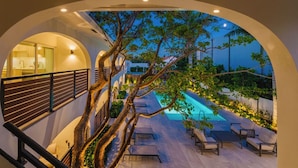 Ein modernes Gebäude mit Pool, Außenbereich und einem Baum in der Mitte.