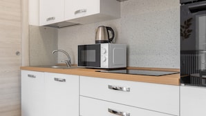 A modern kitchen with a microwave, kettle, and stainless steel sink. - Sogno del Garda by Wonderful Italy (Desenzano del Garda)