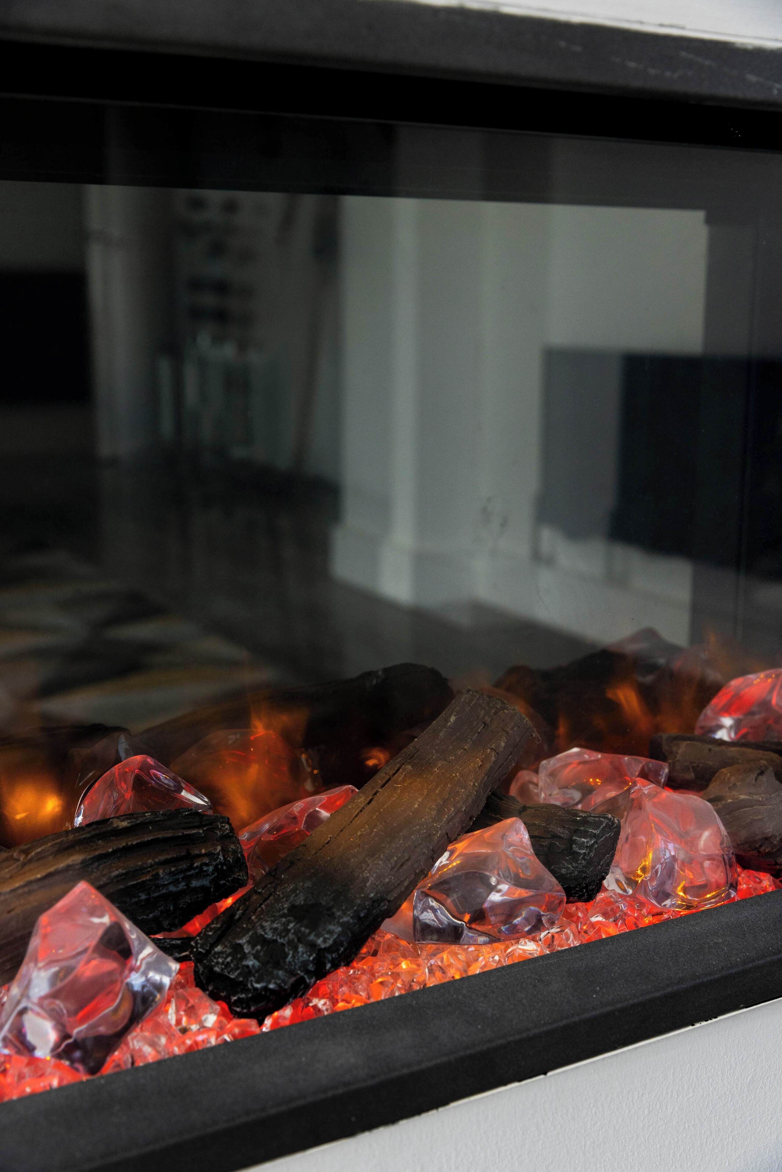 A fireplace with logs and glowing embers.