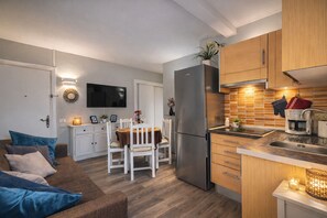 A modern kitchen with a refrigerator, stove, and sink, a dining area with a table and chairs, and a living room with a sofa and a TV. - Puerto de la cruz (Puerto de la Cruz)