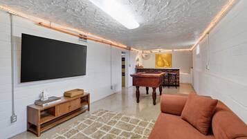 Una sala de estar moderna con un televisor de pantalla plana, muebles de madera, una mesa de centro y un sofá.