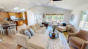 A spacious living room with a sofa, armchairs, a coffee table, and a dining area with chairs and a table. - Amazing Ocean view 1 mile to Brookings! (Brookings)