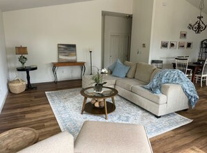 A living room with a sofa, coffee table, and a dining area with chairs and a table. - Amazing Ocean view 1 mile to Brookings! (Brookings)