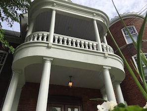 Un edificio de dos pisos con balcón y fachada de ladrillo.
