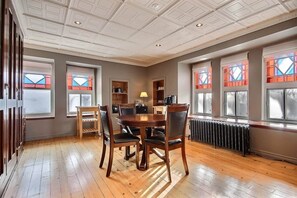A dining area with a round table, chairs, and a radiator. - Les Ancestrales - Suite romantique (Saint-Hyacinthe)