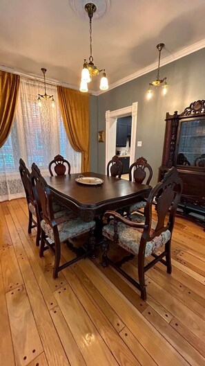 A dining room with a wooden table, chairs, and a chandelier.