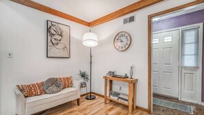 Una sala de estar con un sofá, una lámpara, un reloj y una puerta.