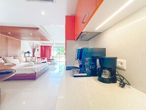 Ein modernes Hotelzimmer mit einem Bett, einer Kaffeemaschine und Blick ins Freie.